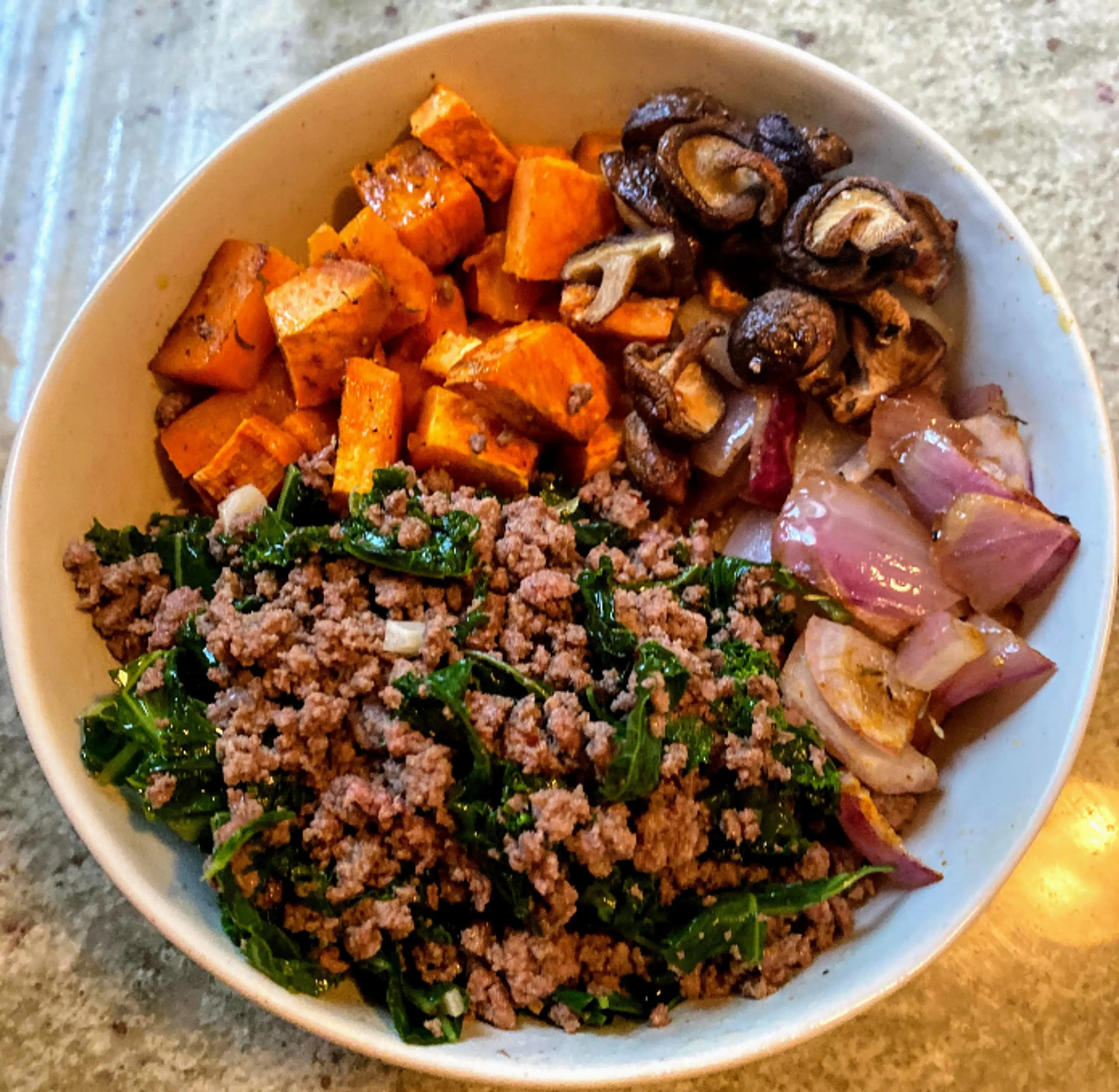 Ground beef bowl with sweet potato, kale, red onion, and mus