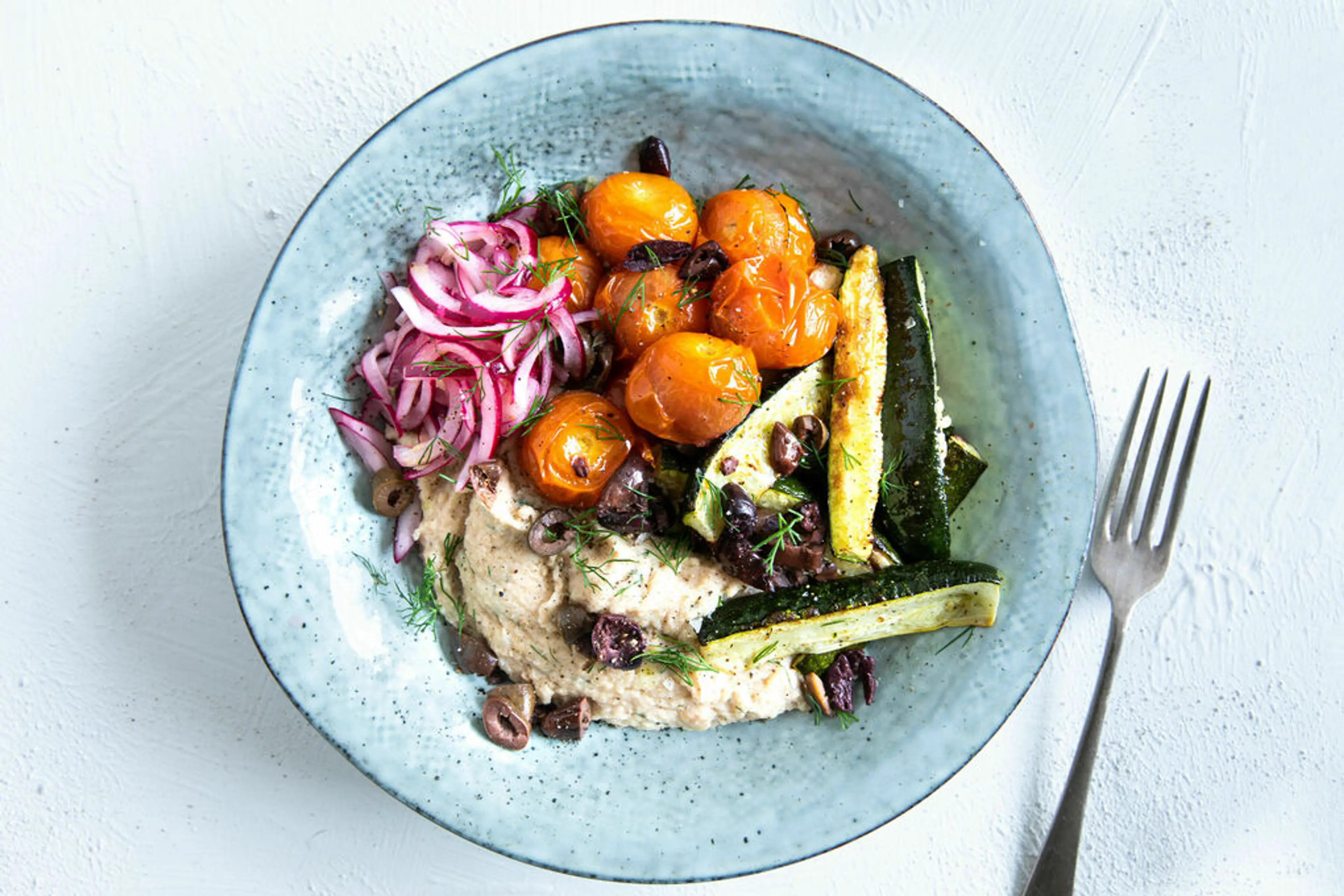 Griekse skordalia-bowl met walnoten, courgette en olijven